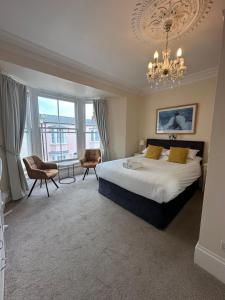 a bedroom with a large bed and a chandelier at Myrtle House Hotel in Tenby