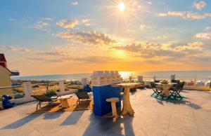 a balcony with a table and chairs and the ocean at Les Petites Canailles Rooftop in Cayeux-sur-Mer