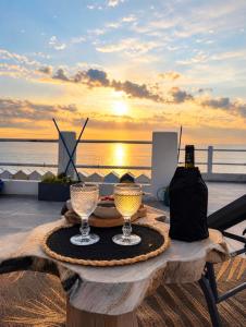 a table with two wine glasses on top of a beach at Les Petites Canailles Rooftop in Cayeux-sur-Mer