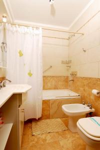 a bathroom with a tub and a toilet and a sink at Complejo Ali Lafken in Las Grutas