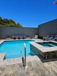 a swimming pool with chairs next to a building at Inn At Juzani Boutique Hotel in Lambeau