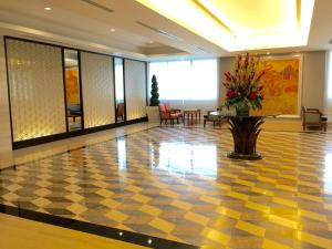 a lobby with a checkered floor and a vase of flowers at Indra Regent Hotel in Bangkok