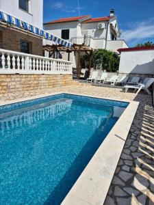 a swimming pool in front of a villa at Kuća za odmor Postonjski in Maslenica