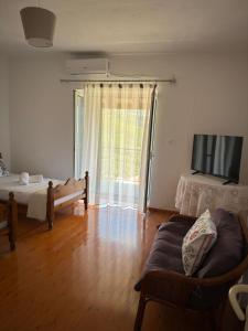 a room with two beds and a television and a couch at M & A Ionian Balcony in Himare