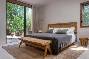 a bedroom with a large bed and a wooden table at 3BR Home in Gated Community with Private Rooftop Plunge Pool, Grill & Shared Pool in Tulum