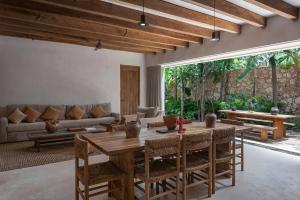 a living room with a wooden table and a couch at 3BR Home in Gated Community with Private Rooftop Plunge Pool, Grill & Shared Pool in Tulum