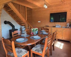 a dining room with a wooden table and chairs at Za Bocianami- domki w Bartoszymlesie in Stara Kiszewa +30 photos