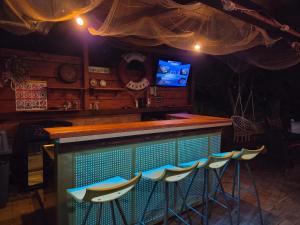 a bar with chairs and a television in a room at Green Glamping Paravia in Krasica