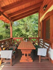 a wooden table and chairs on a wooden deck at Za Bocianami- domki w Bartoszymlesie in Stara Kiszewa