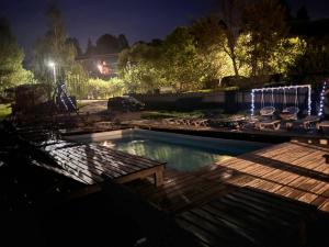 a swimming pool at night with chairs and lights at Trostjn house in Slavske