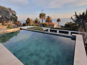 a swimming pool with a view of the ocean at Villa Naussica in Saint-Raphaël
