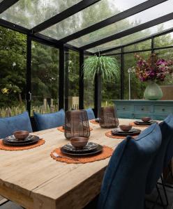 a wooden table in a conservatory with chairs and a wooden tableastery at Parc La Dune Marrakesh Lodge in Warmenhuizen