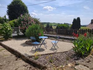 two chairs and a table in a garden at Gîte les Huttières in Cravant-les-Coteaux