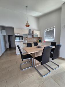 a kitchen and dining room with a wooden table and chairs at Kuća za odmor Postonjski in Maslenica