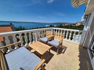 a balcony with two benches and a view of the water at Kuća za odmor Postonjski in Maslenica