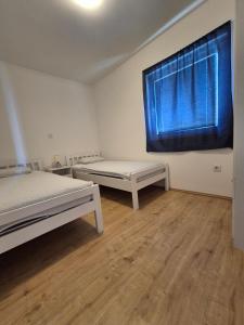a bedroom with two beds and a large window at Kuća za odmor Postonjski in Maslenica +33 photos