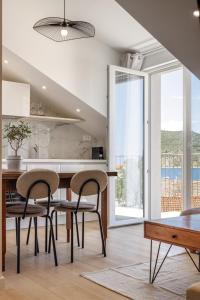 a kitchen with a dining table and chairs and a large window at Villa Mare's in Primošten