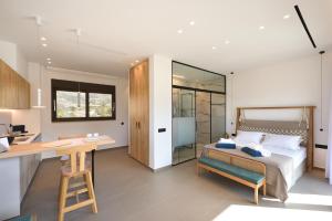 a bedroom with a bed and a desk and a kitchen at My Aloni Luxury Residences in Plakias