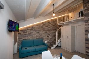 a living room with a blue couch and a brick wall at AL 54 Accommodation - Premium in San Benedetto del Tronto +35 photos