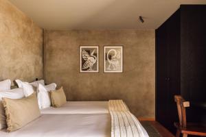 a bedroom with a bed with two pictures on the wall at Residence - Signature Villas in Lagoa +75 photos