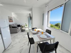 a dining room and living room with a table and chairs at Alexandros Luxury Apartment in Glossa