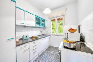 a kitchen with white cabinets and a sink at Villa Panorama with Private Pool in Nago-Torbole