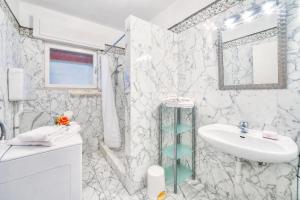 a white bathroom with a sink and a mirror at Villa Panorama with Private Pool in Nago-Torbole +32 photos