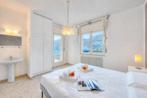 a white bedroom with a bed and a sink at Villa Panorama with Private Pool in Nago-Torbole