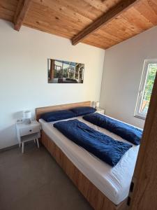 a bedroom with a large bed with blue pillows at Panorama Chalet Fahner Höhe nahe Erfurt mit Klimaanlage in Witterda