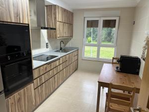 a kitchen with wooden cabinets and a sink and a table at Pilgrims House II in Lourenzá +17 photos