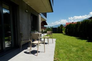a patio with chairs and a table on the grass at Alpenlodge Haus - Summer resort with Schladming-Dachstein Card in Haus im Ennstal