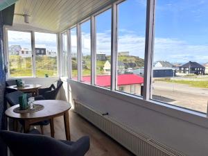 a room with windows and a table and chairs at The Stykkishólmur Inn by Ourhotels in Stykkishólmur