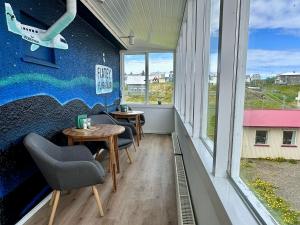a room with two tables and a wall with windows at The Stykkishólmur Inn by Ourhotels in Stykkishólmur +21 photos
