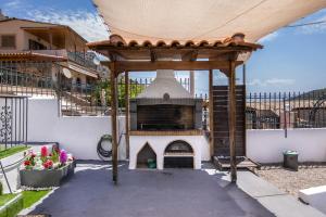 a outdoor pizza oven with a roof on a patio at Ξενώνας της Αγάπης in Salamina
