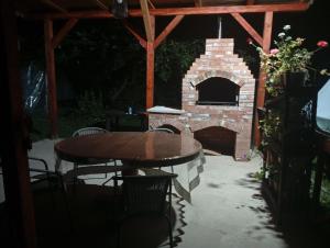 a patio with a table and a brick oven at Casa Carmen in Târgu Ocna