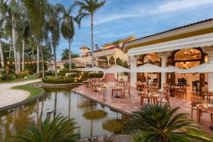 a restaurant with tables and umbrellas in front of a building at Casa Velas Adults Only All Inclusive in Puerto Vallarta
