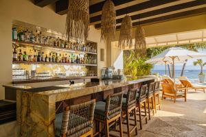 a bar in a resort with a view of the ocean at Casa Velas Adults Only All Inclusive in Puerto Vallarta