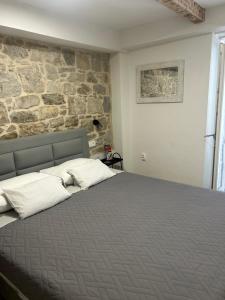 a bedroom with a bed with a stone wall at Apartman Blue Moon Split- free parking in Split