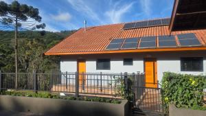 a house with solar panels on the roof at Shoresh Araucária in Campos do Jordão