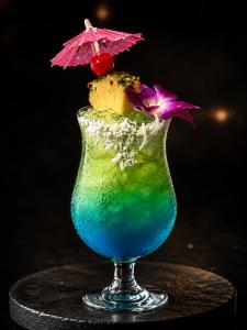 a glass with a blue drink with an umbrella at Ramada by Wyndham Austin South in Austin
