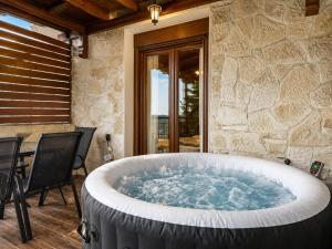 a large tub in a patio with a table and chairs at Villas Lirtzis in Taxiarchis