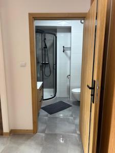 a bathroom with a glass shower and a toilet at SWP Plac Solny 4 z klimatyzacją in Głogów +11 photos