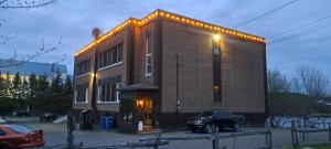 a truck parked in front of a brick building with lights at Manoir Des Lacs in Lac Baker