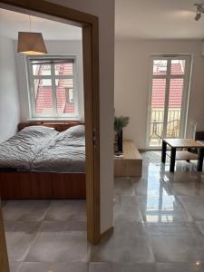 a bedroom with a bed and a table and two windows at SWP Plac Solny 4 z klimatyzacją in Głogów