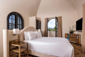 a bedroom with a white bed and a window at Montecito Inn in Santa Barbara