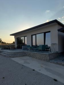 a house with a patio with chairs and tables at ALAR Rooms in Dhërmi