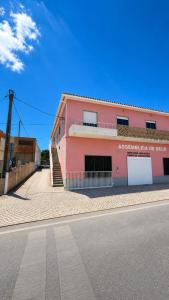 a pink building on the side of a street at Albani Hostel in Palmela