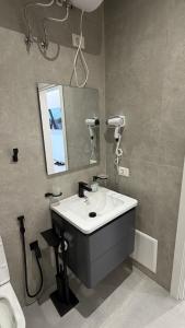 a bathroom with a sink and a mirror at ALAR Rooms in Dhërmi