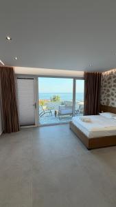 a bedroom with a bed and a view of the ocean at ALAR Rooms in Dhërmi