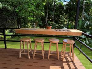 a wooden table and four stools on a deck at Río Celeste Stay in Rio Celeste